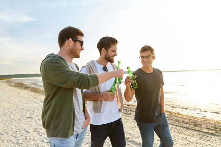 friends enjoying alcohol-free beer on the beach