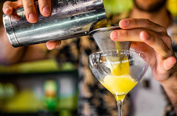 Bartender pouring passionfruit martini mocktail